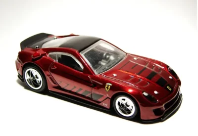Carrinho de brinquedo esportivo vermelho com detalhes pretos, inspirado em carros de corrida de alta performance, perfeito para colecionadores e crianças.