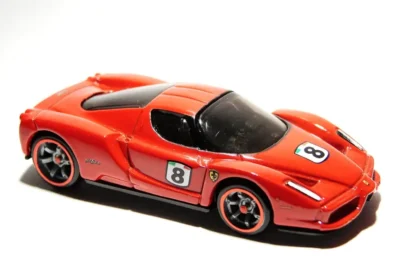 Carro de corrida em escala menor com detalhes vermelhos, com número 8 na lateral e detalhes de Ferrari, destacando-se por sua aparência esportiva e design aerodinâmico.