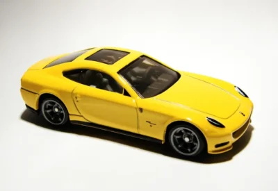 Modelo de carro esportivo amarelo com detalhes em preto, destaque na parte frontal e rodas esportivas, ideal para entusiastas de veículos de alta performance.