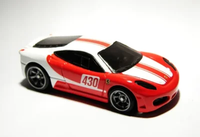 Carro de corrida com design esportivo vermelho, branco e preto, com o número 430 e detalhes aerodinâmicos, para colecionadores e entusiastas.